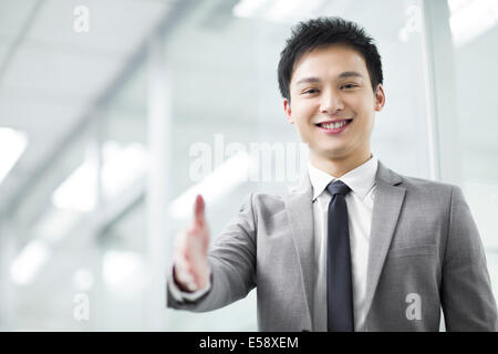 Young businessman extending hand for handshake Stock Photo