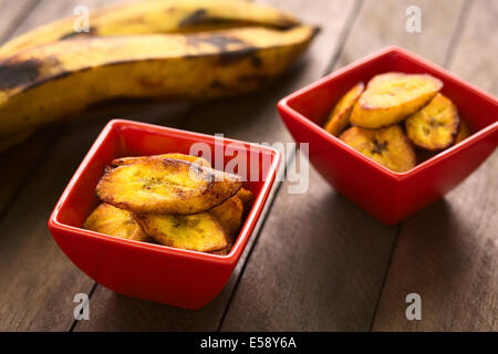 Fried slices of the ripe plantain in small red bowls Stock Photo