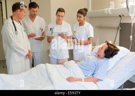 Medical team attending female patient on hospital bed Stock Photo