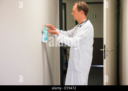Male doctor using hygiene hand wash in hospital room Stock Photo