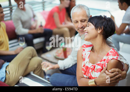 Couple hugging at party Stock Photo