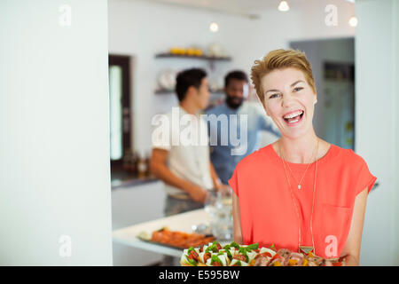 Woman carrying tray of food at party