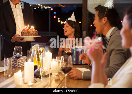 Man serving birthday cake at party Stock Photo