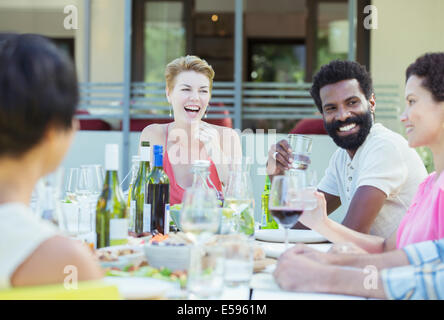 Friends talking at table outdoors Stock Photo