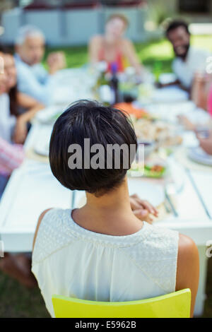 Woman sitting at table outdoors Stock Photo
