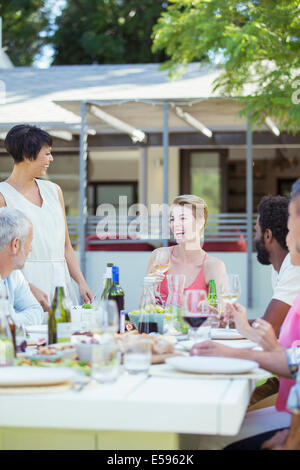 Friends eating together at table outdoors Stock Photo