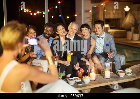 Woman taking picture of friends at party Stock Photo