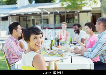 Woman smiling at table outdoors Stock Photo