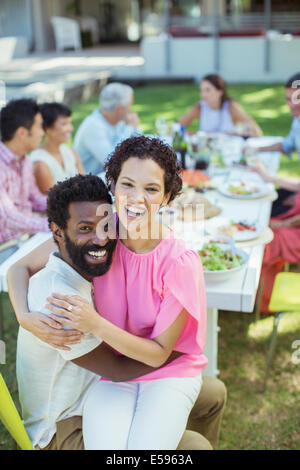 Couple hugging at table outdoors Stock Photo