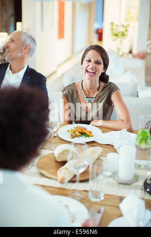 Woman laughing at dinner party Stock Photo