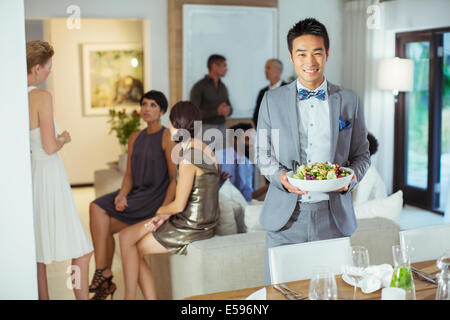 Man serving food at dinner party Stock Photo