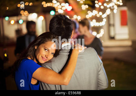 Couple hugging at party