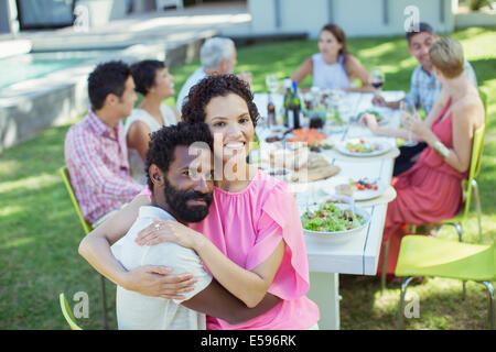 Couple hugging at table outdoors Stock Photo