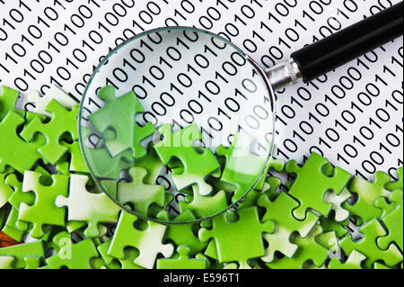 puzzles and magnifying glass on a binary code Stock Photo