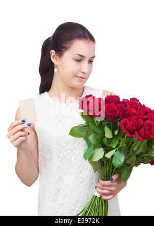 Young beautiful girl in white dress with bouquet of red roses and business card in hand isolated on white background. Stock Photo