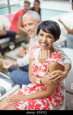 Couple hugging at party Stock Photo