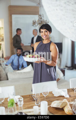 Woman serving food at dinner party Stock Photo