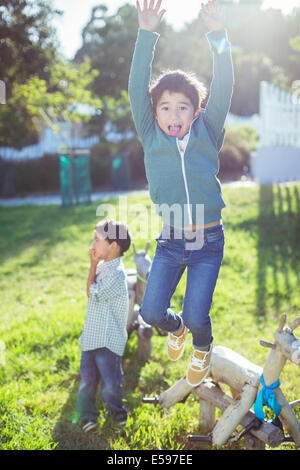 Boy jumping for joy outdoors Stock Photo