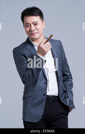 Mature businessman smoking cigar Stock Photo