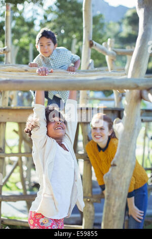 Teachers and students playing on play structure Stock Photo