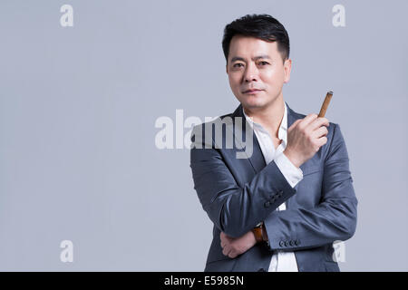 Mature businessman smoking cigar Stock Photo