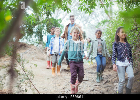 Students and teacher walking in forest Stock Photo