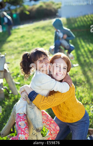 Student and teacher hugging outdoors Stock Photo