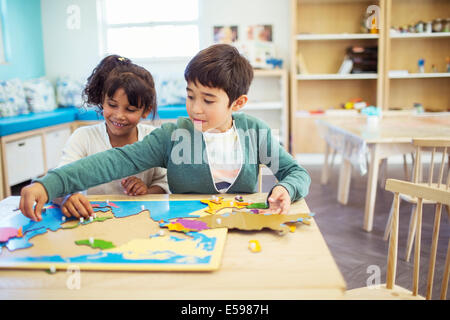 Students doing puzzle in classroom Stock Photo