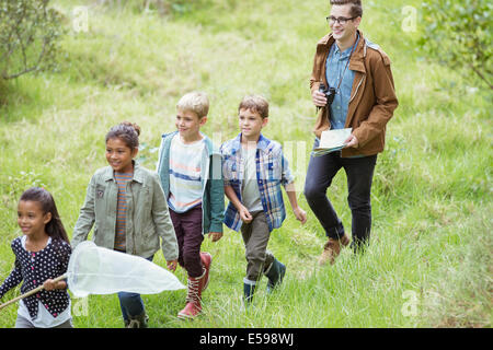Students and teacher walking in field Stock Photo