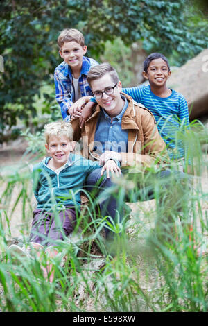 Students and teacher smiling in forest Stock Photo
