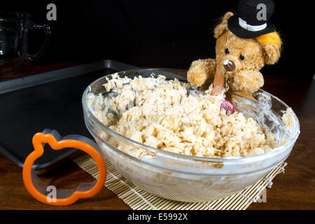 Cute thanksgiving pilgrim bear making pumpkin shaped puffed rice cereal cookie treats Stock Photo