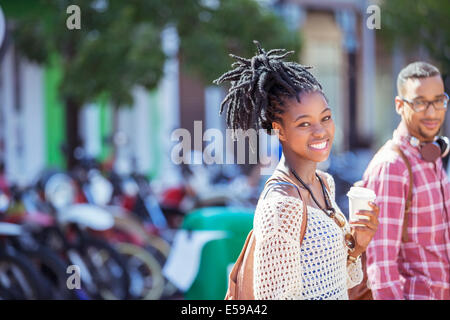 Woman drinking coffee on city street Stock Photo