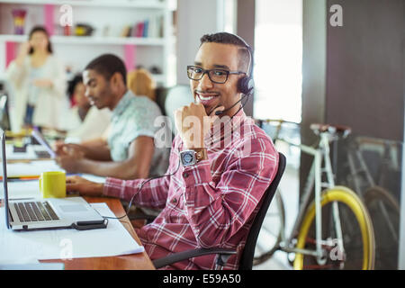 Man smiling at desk in office Stock Photo