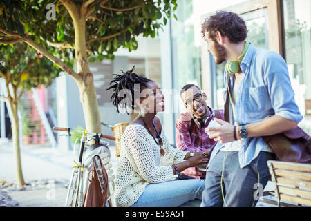 Friends talking on city street Stock Photo