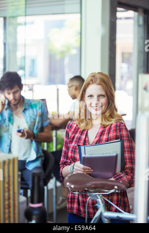 Woman carrying folders in cafe Stock Photo