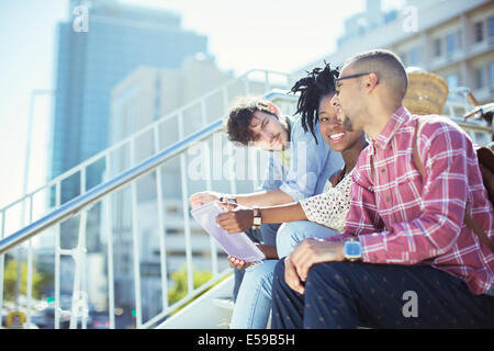 Friends sitting on city steps Stock Photo