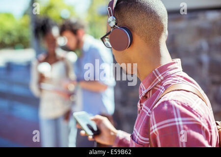 Man listening to mp3 player outdoors Stock Photo
