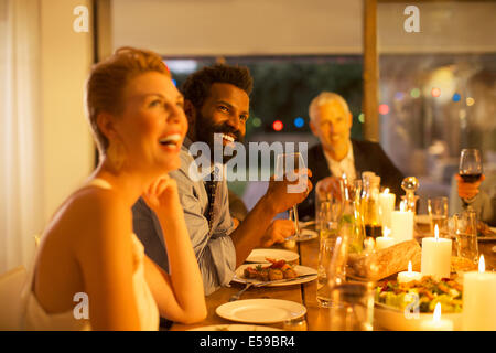 Friends laughing at dinner party Stock Photo