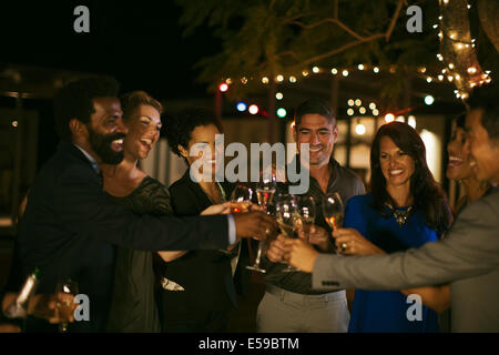 Friends toasting each other at party Stock Photo