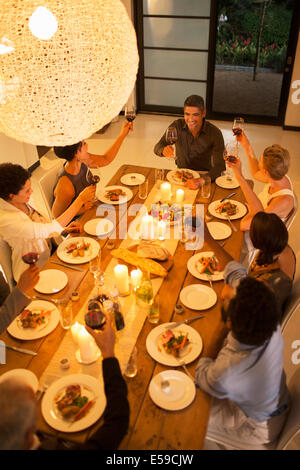 Friends toasting each other at dinner party Stock Photo