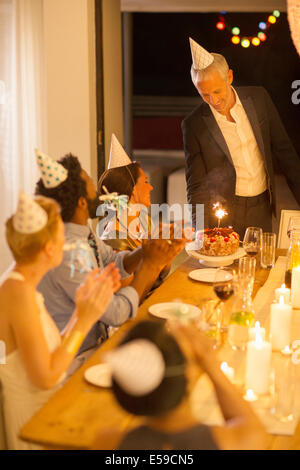 Man serving birthday cake at party