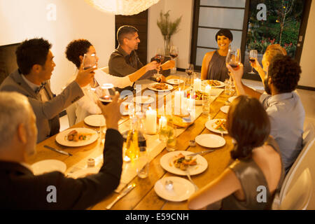 Friends toasting each other at dinner party Stock Photo