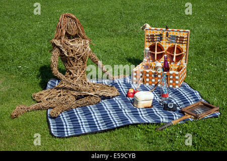 Manchester, UK. 23rd July, 2014. Seated female figure, Wickerwork, plaited or woven twigs or osiers Sculptures picnic basket outside, a Willow basket creation artwork that wows at the RHS - Royal Horticultural Society carnival-themed event at Tatton Park. Stock Photo