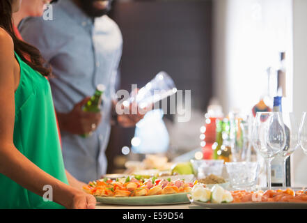 Woman with plates of food at party Stock Photo