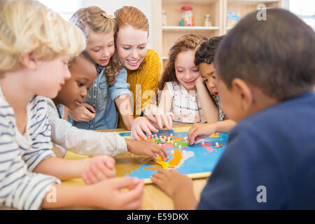 Teacher playing with students in classroom Stock Photo