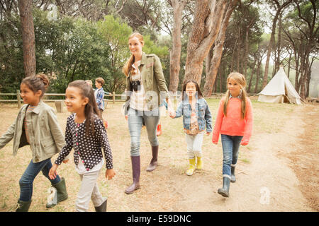 Students and teacher walking on dirt path Stock Photo