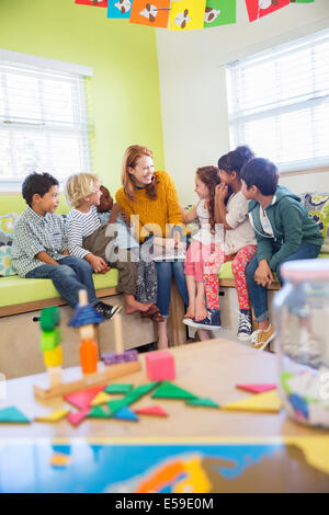 Teacher and students reading in classroom Stock Photo