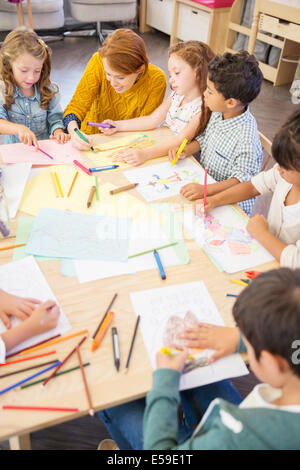 Students and teacher drawing in classroom Stock Photo