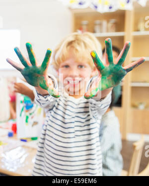 Student showing off messy hands in classroom Stock Photo