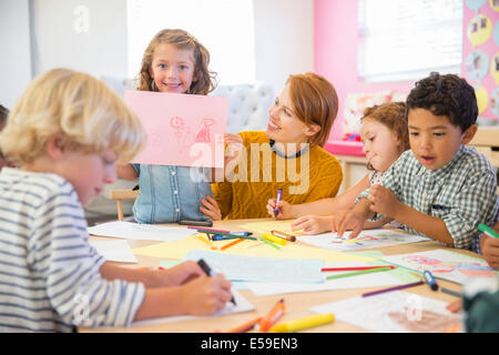 Student showing off drawing in classroom Stock Photo